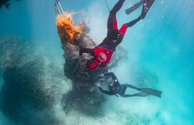 Photo: Divers gather fishing nets from the reef