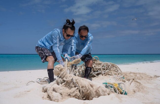 Photo: Kenika Lorenzo-Elarco and Hau&lsquo;oli Lorenzo-Elarco of the Papahānaumokuākea Native Hawaiian Cultural Working Group work to remove a large fishing net