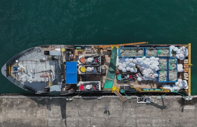 Photo: Vessel with piles of collected marine debris