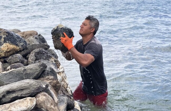 Photo: Volunteer lifting a rock