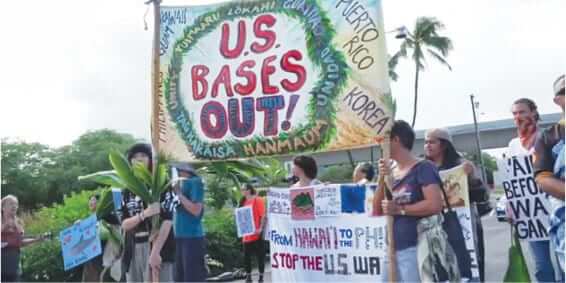 Photo: Members of the Hoʻopae Pono Peace Project hold signs near Pearl Harbor